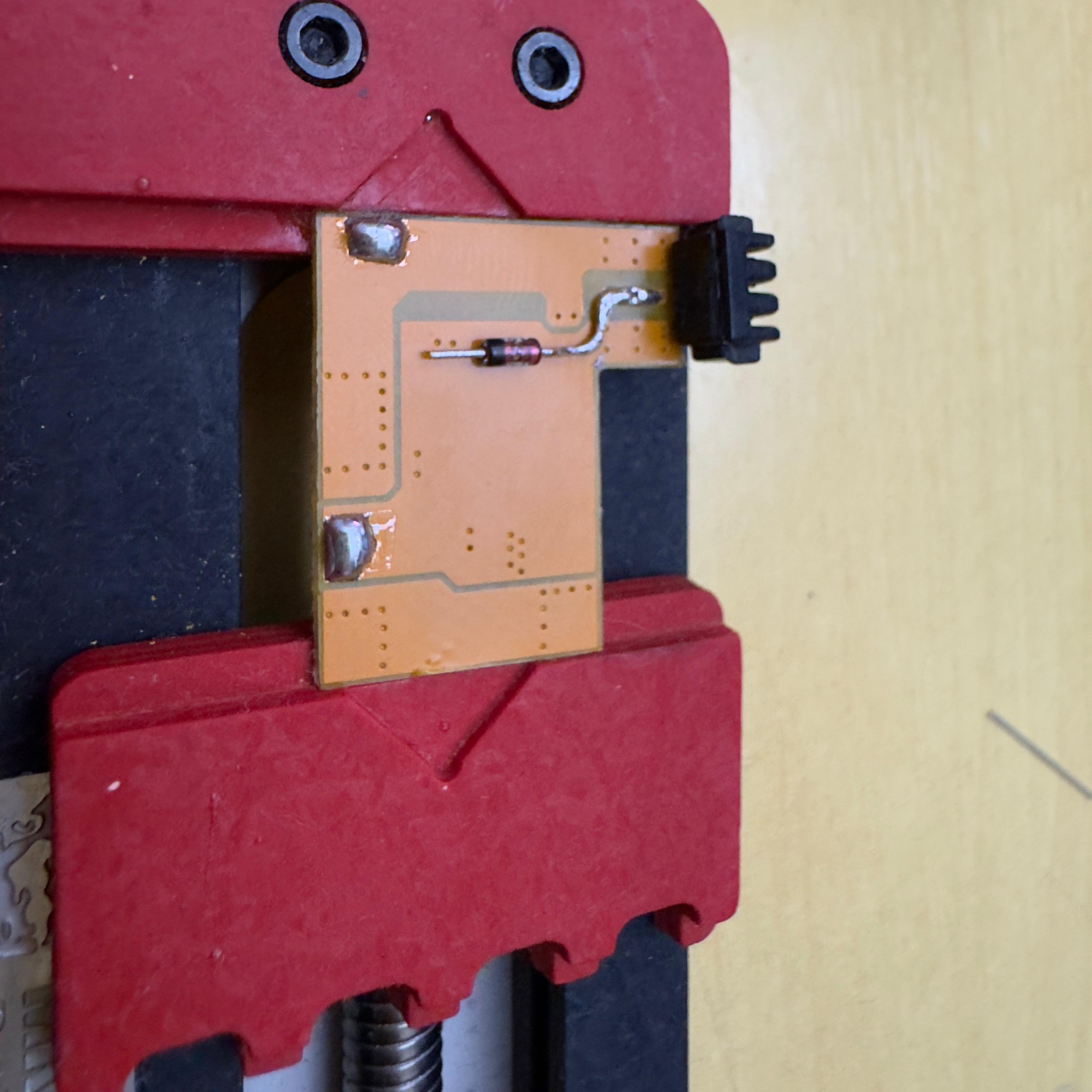 1N4148 soldered to the battery PCB, with one leg bent into an L